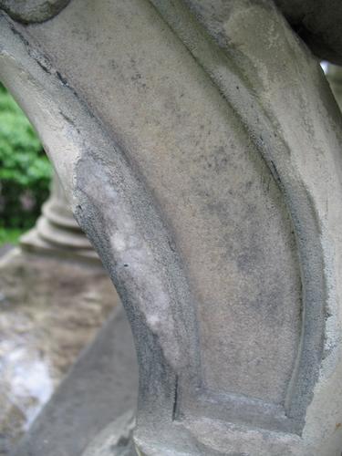 Темноокрашенные колонии грибов на вертикальной поверхности мрамора. Загрязнения в виде серого налета на поверхности мрамора. Ножка саркофага. Западная сторона памятника.