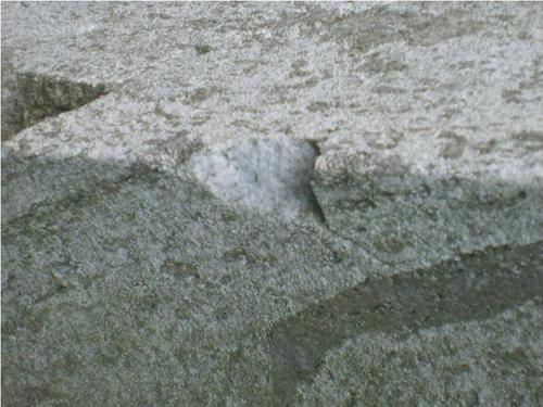 Трещины, выбоины и грязевые наслоения на сером мраморе

