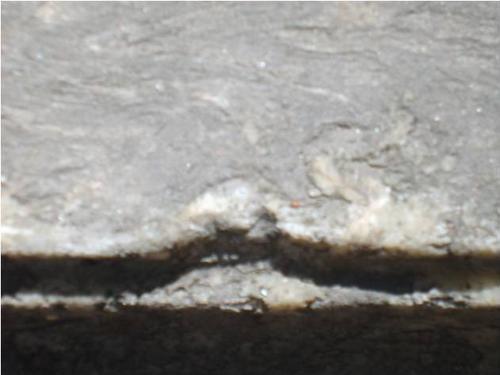 Проявление микрокарста, скол неизвестного происхождения и
атмосферные грязевые отложения на сером мраморе.

