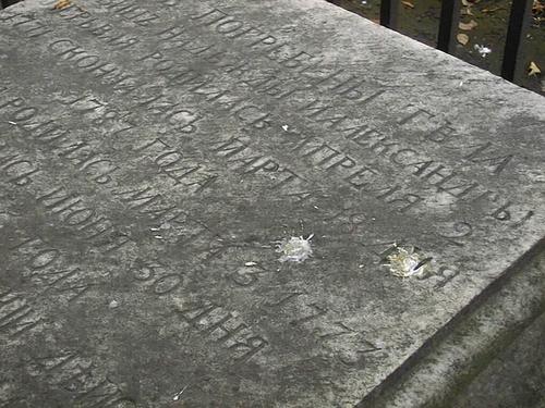 Фрагмент надгробной плиты из белого,
мелко-, среднезернистого мрамора. Видны атмосферные
грязевые отложения, помет птиц. Фото июля 2002 г.

